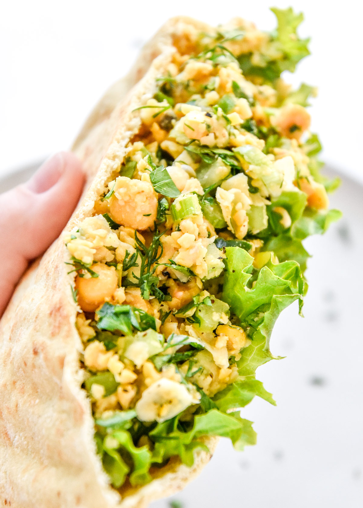 herby lemon mashed chickpea salad in a pita with lettuce.