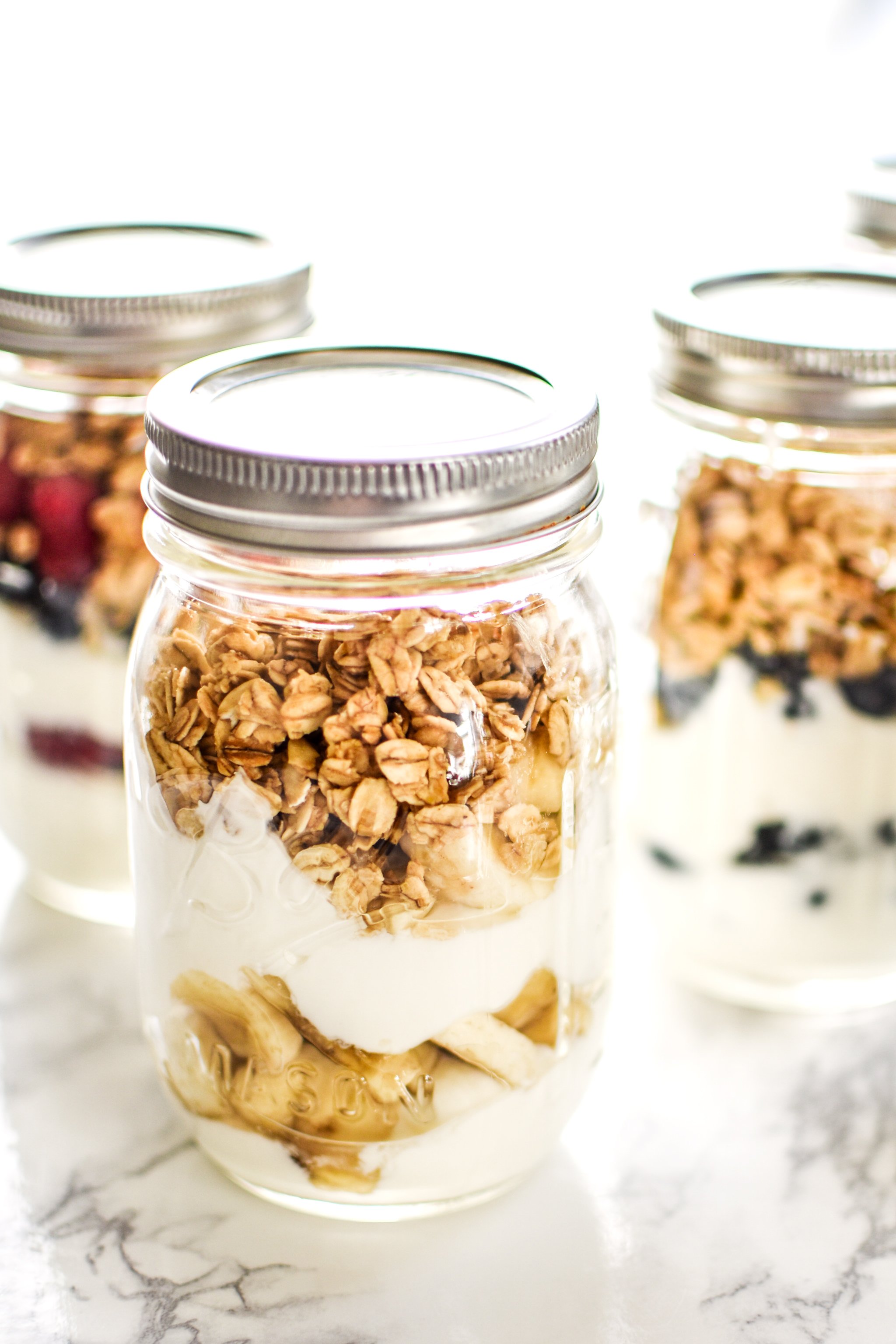 Mason jar green yogurt parfaits with granola and fruit.