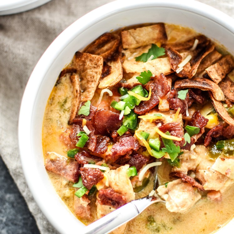 A bowl of jalapeno popper chicken soup with toppings from above.
