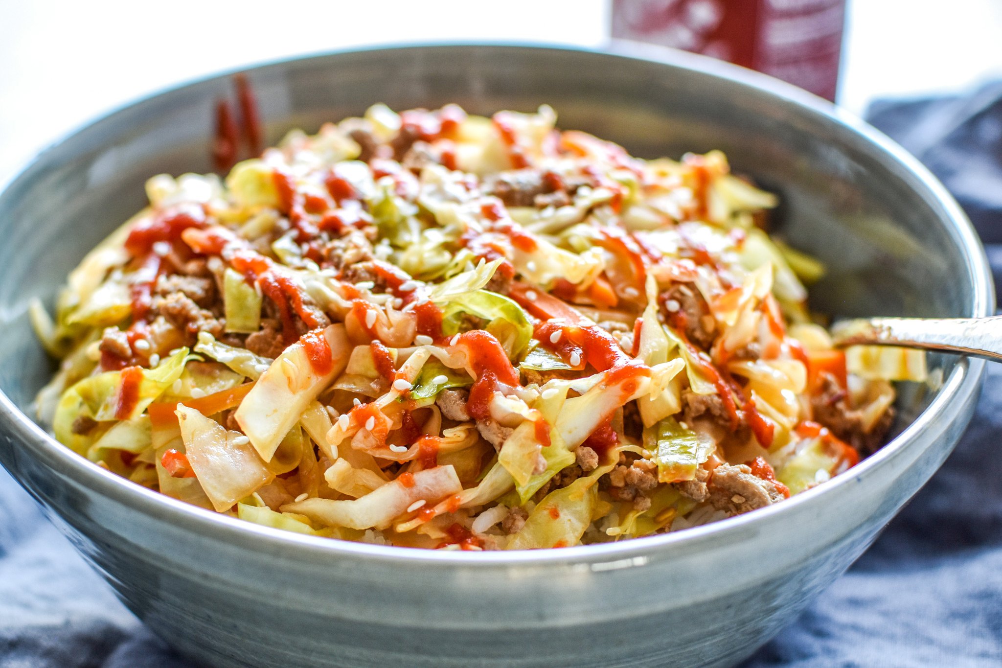 A bowl of spicy ground turkey & cabbage stir fry meal prep with rice.