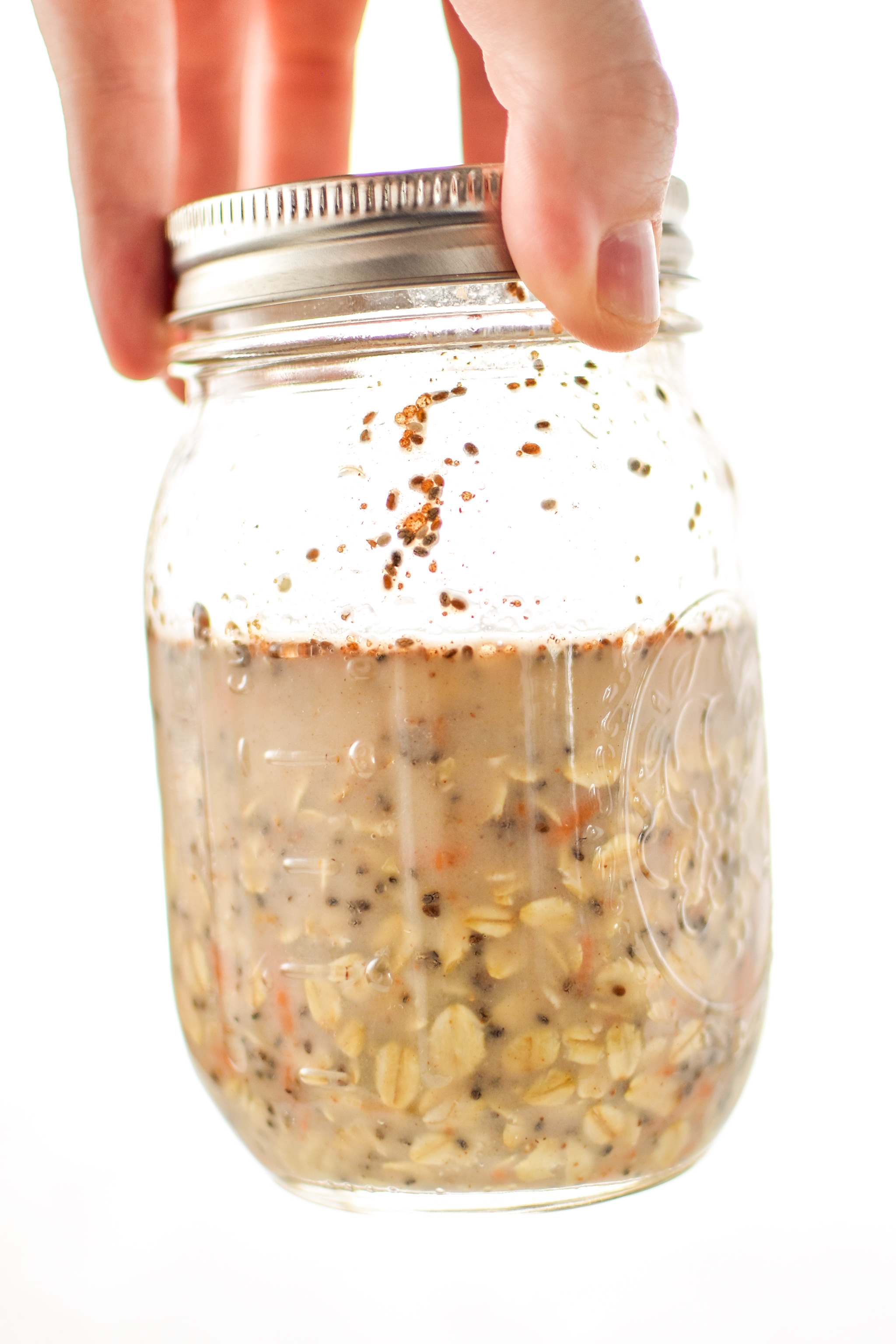 a mason jar ready to go into the fridge full of carrot cake overnight oats