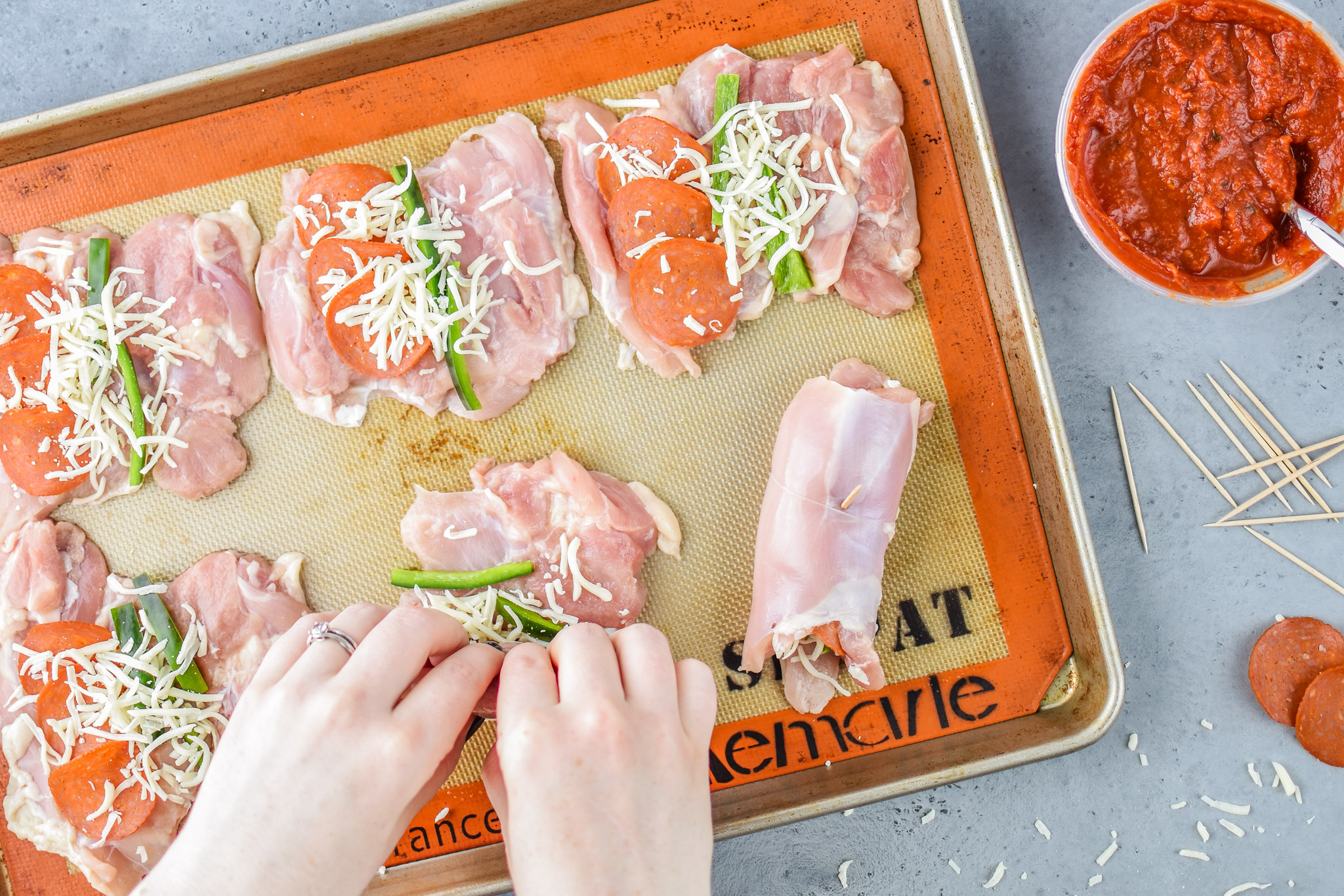 Rolling the chicken for the Pizza Chicken Roll Ups Meal Prep
