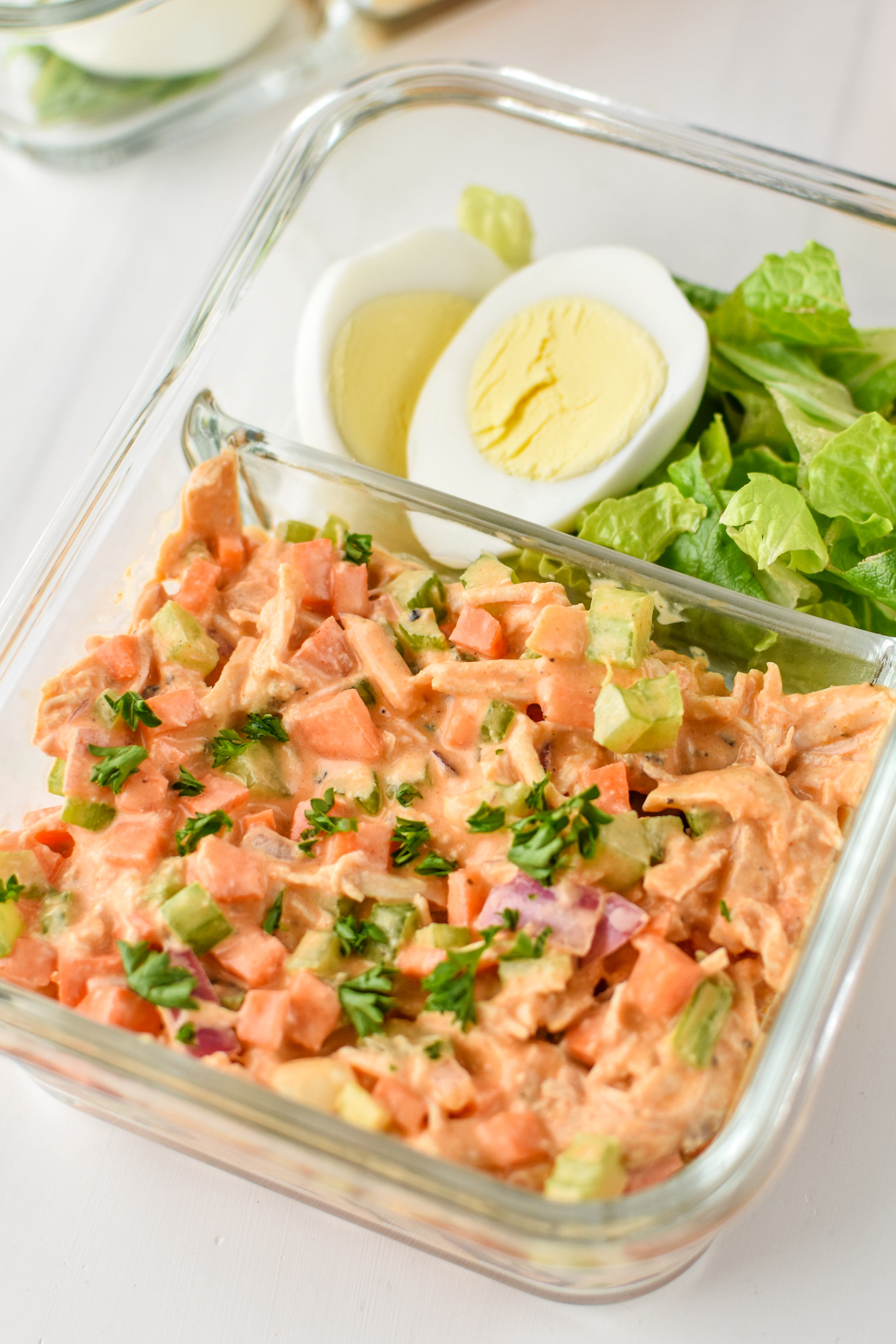 Easy Buffalo Chicken Salad meal prepped with a hard boiled egg and chopped romaine