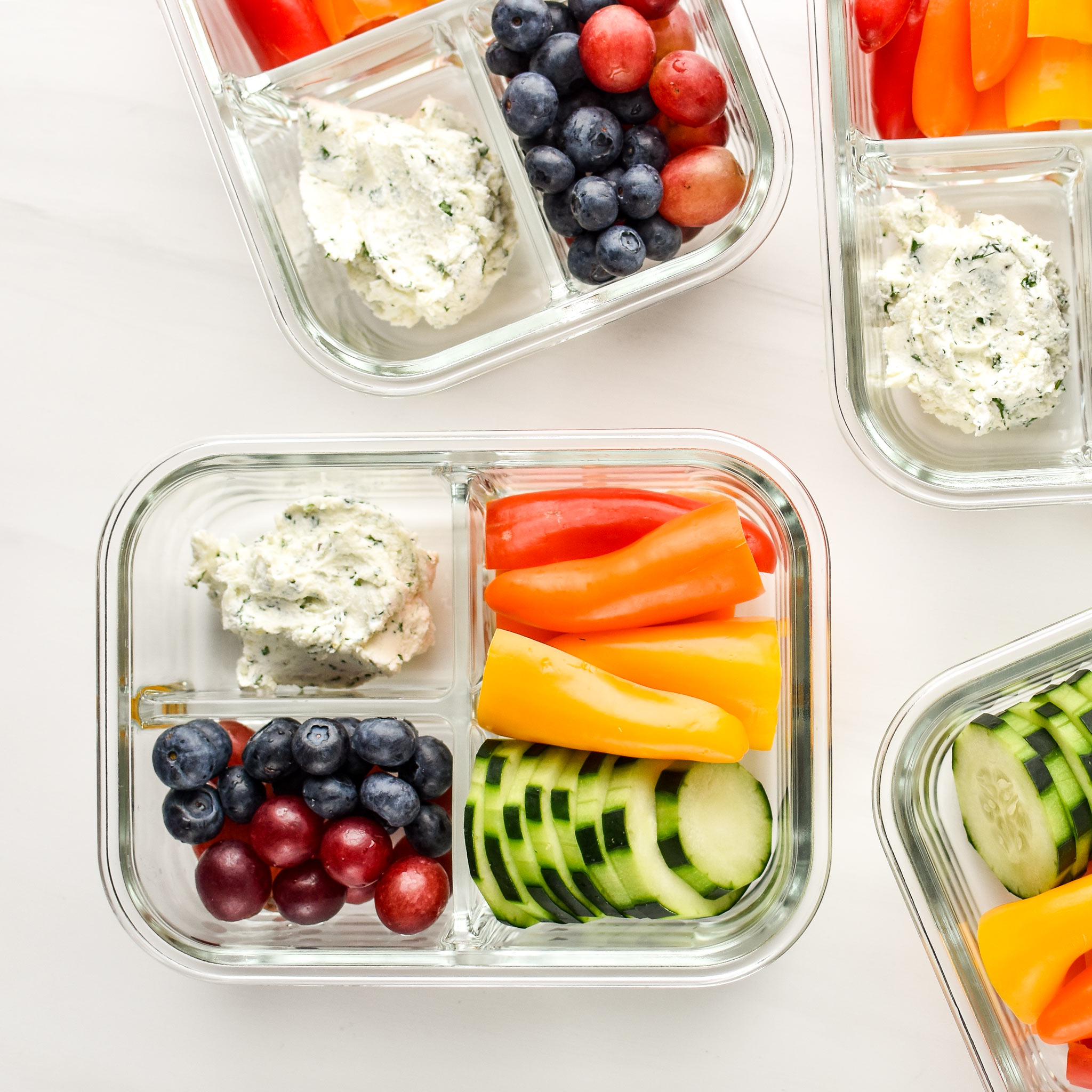 Herbed goat cheese rainbow snack boxes meal prepped in glass containers.