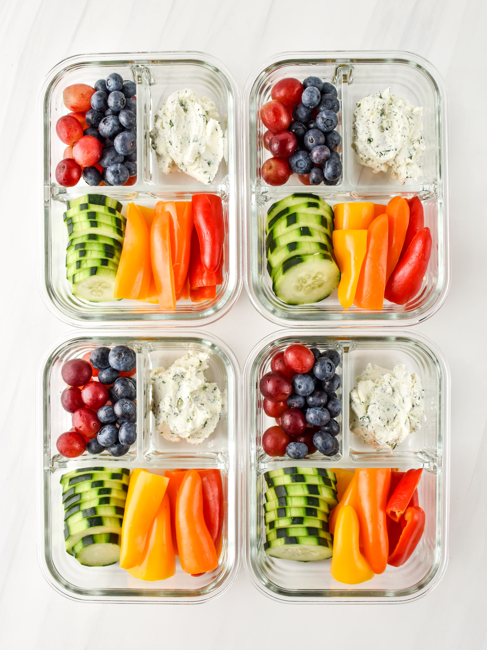 Herbed Goat Cheese Rainbow Snack Boxes in four meal prep containers pictured from above.