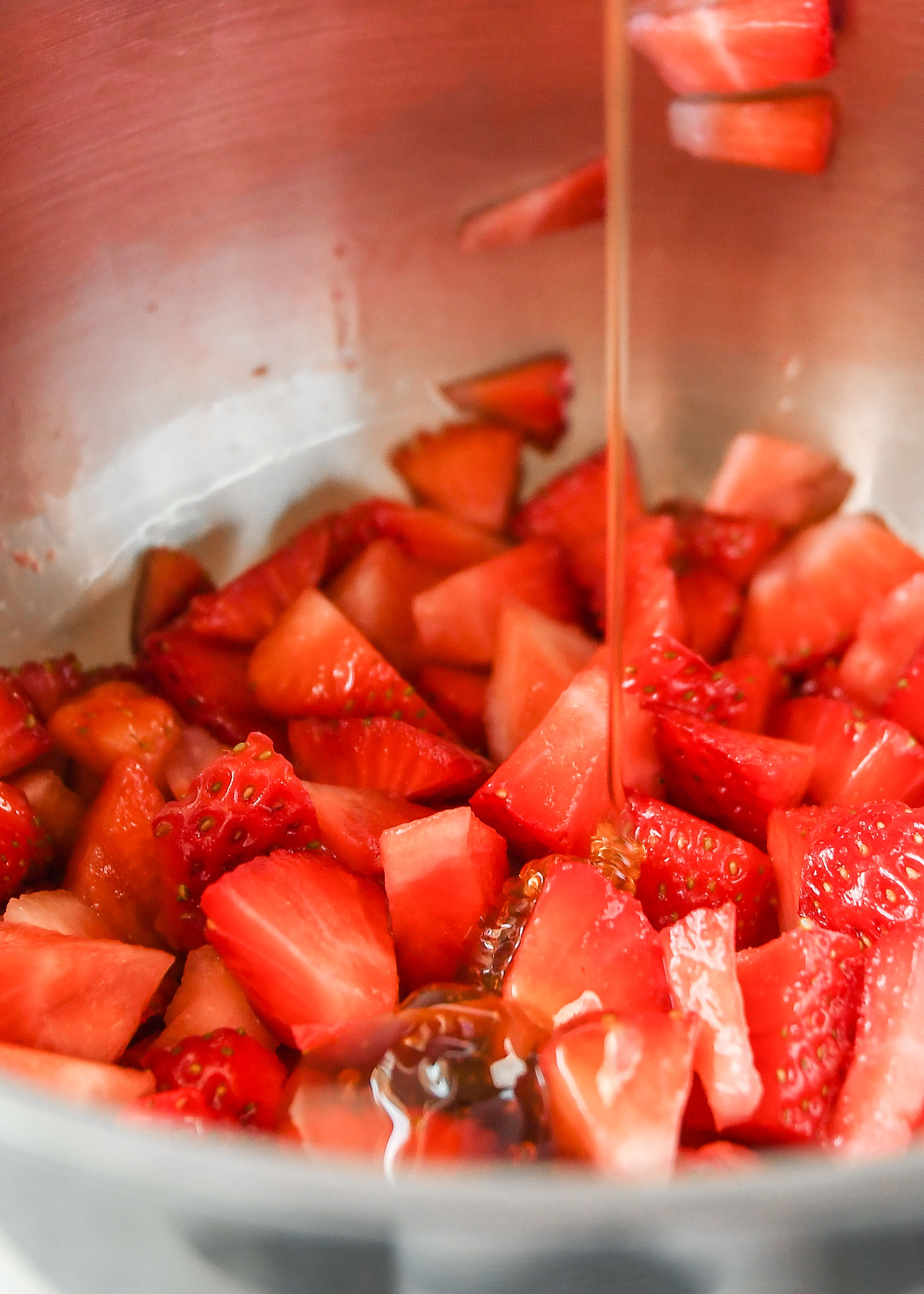 adding honey to strawberries to make the easy strawberry sauce