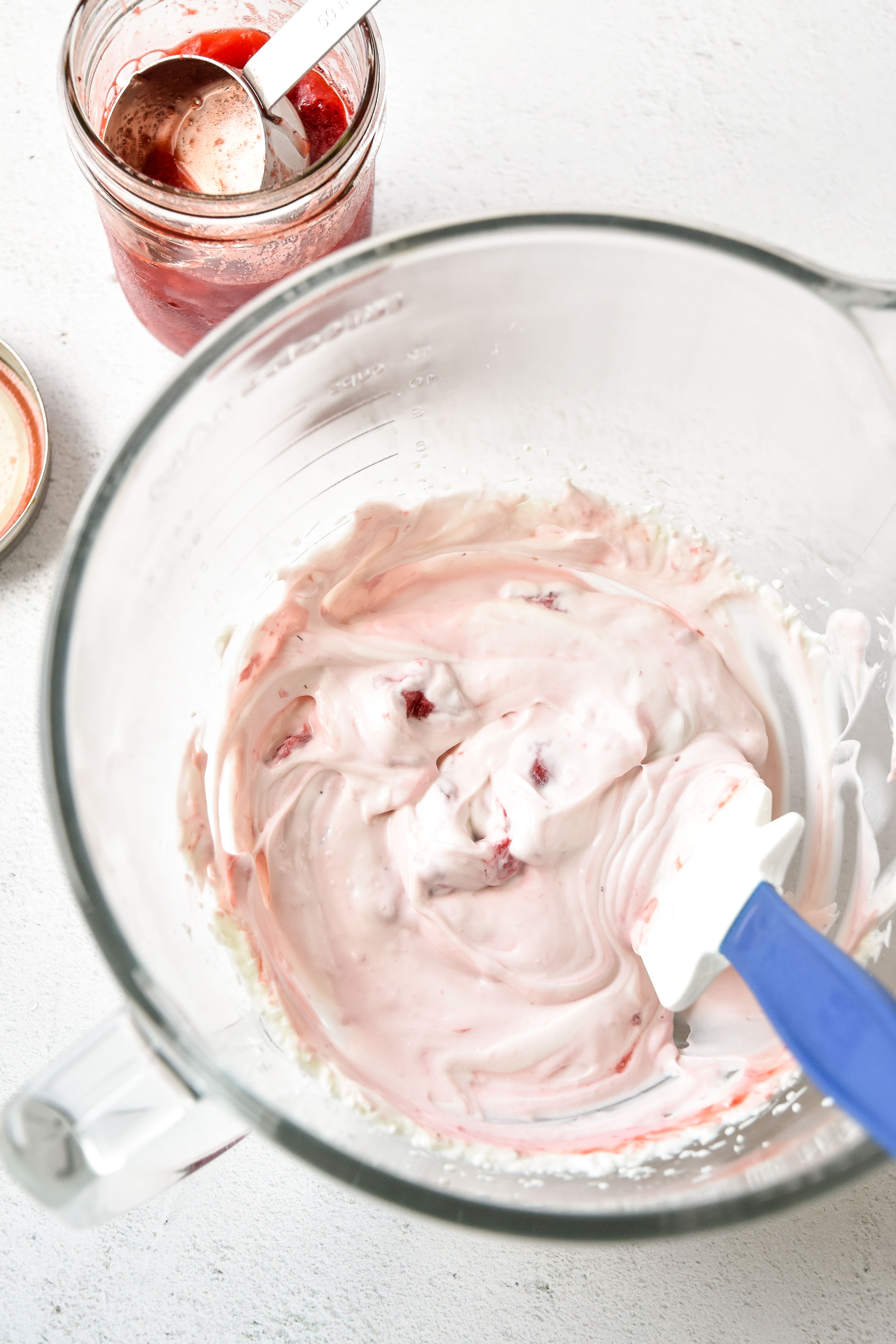 mixing in the strawberry sauce to the whipped greek yogurt