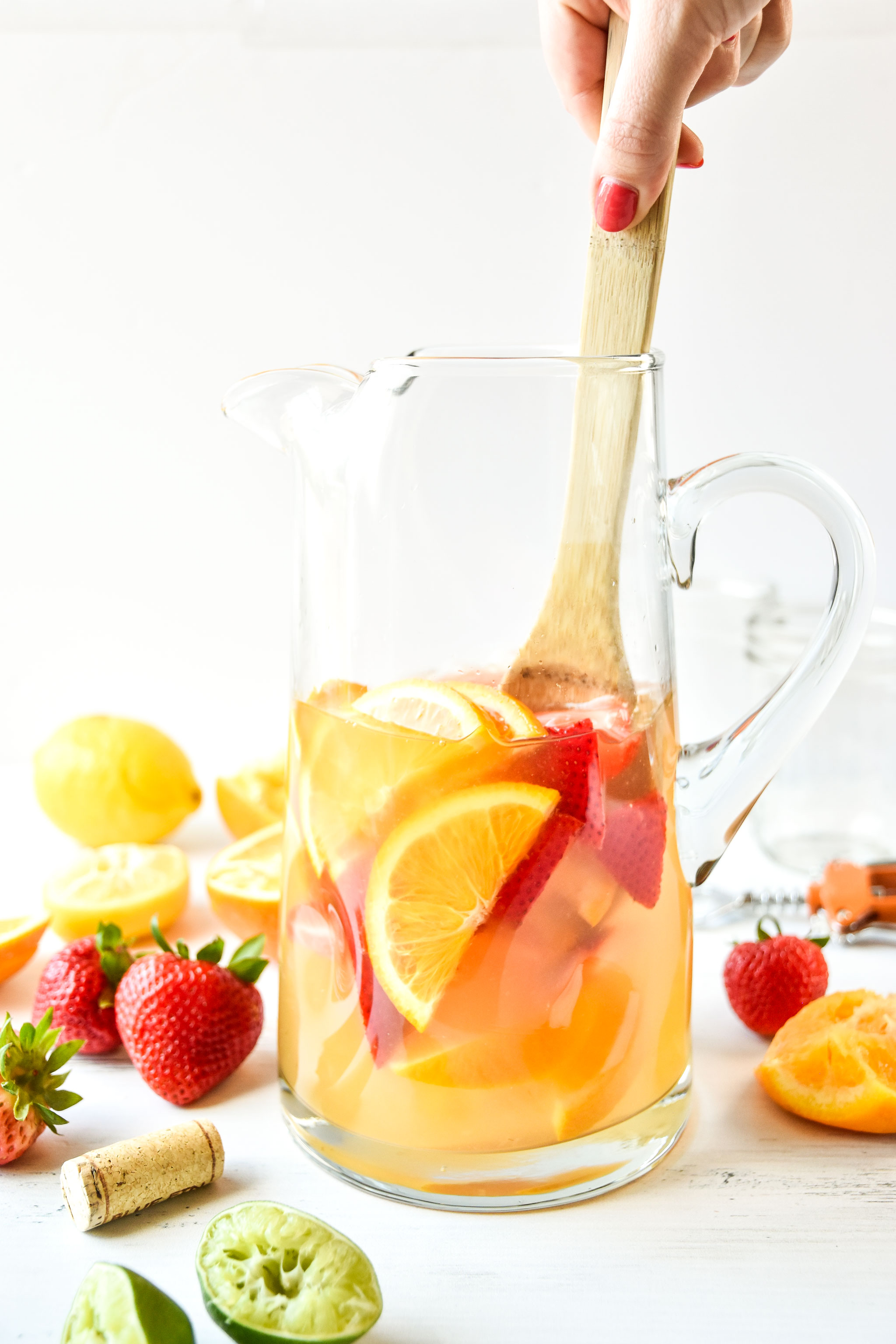 Pitcher of summer white wine sangria being stirred