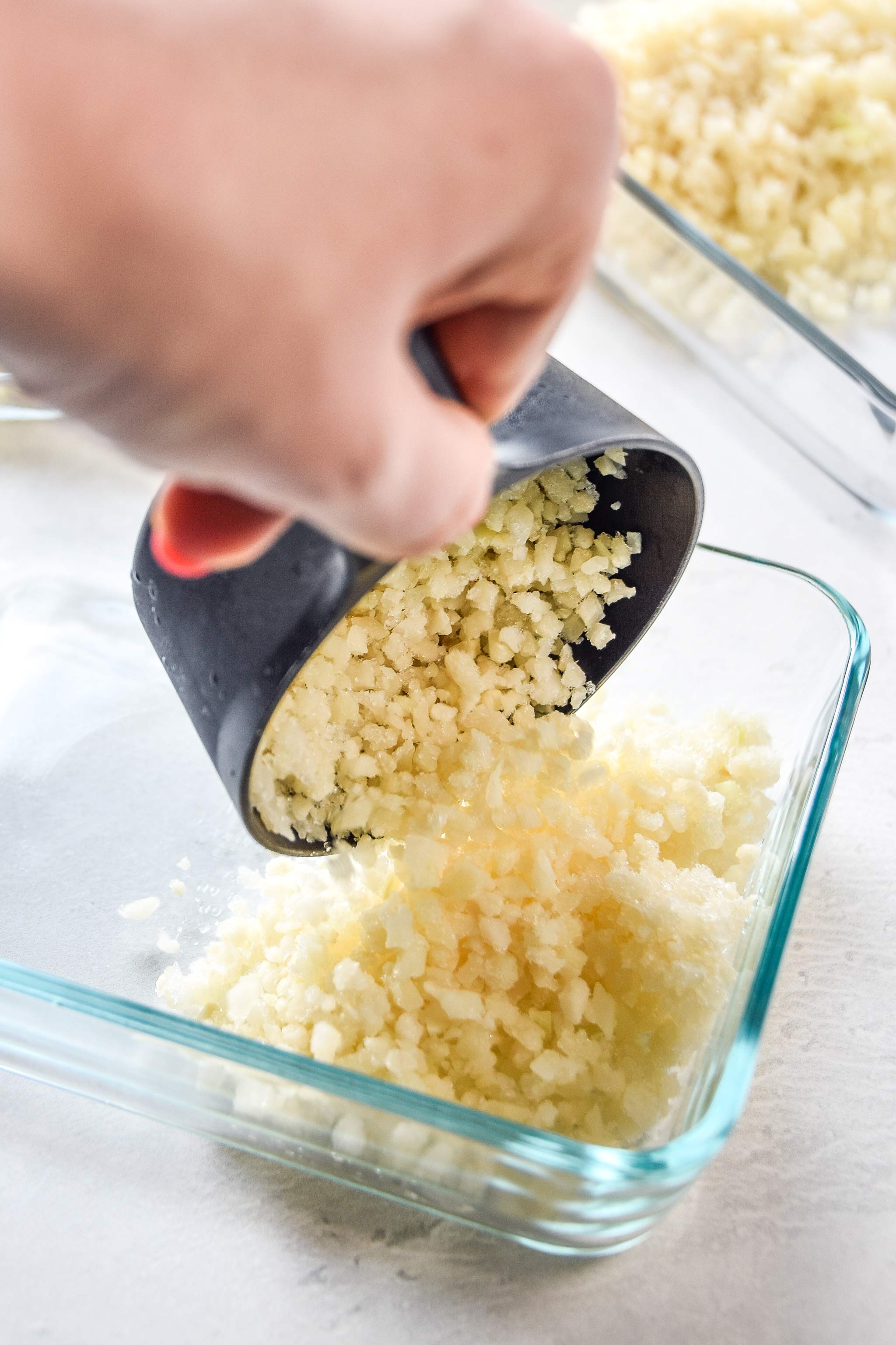 adding cauliflower rice to the meal prep bowl