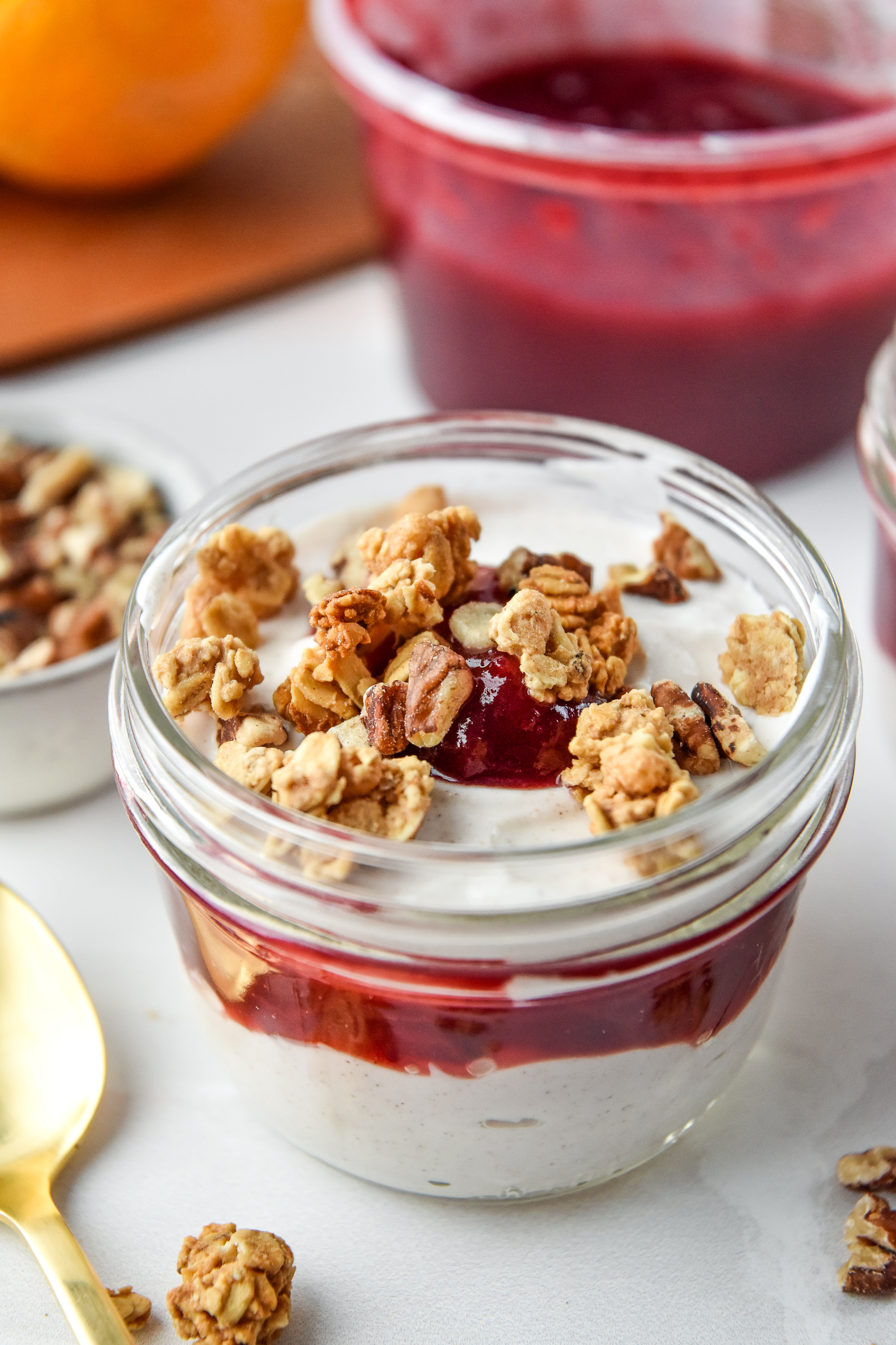 Cinnamon Orange Cranberry Yogurt Parfaits in mason jars with granola on top