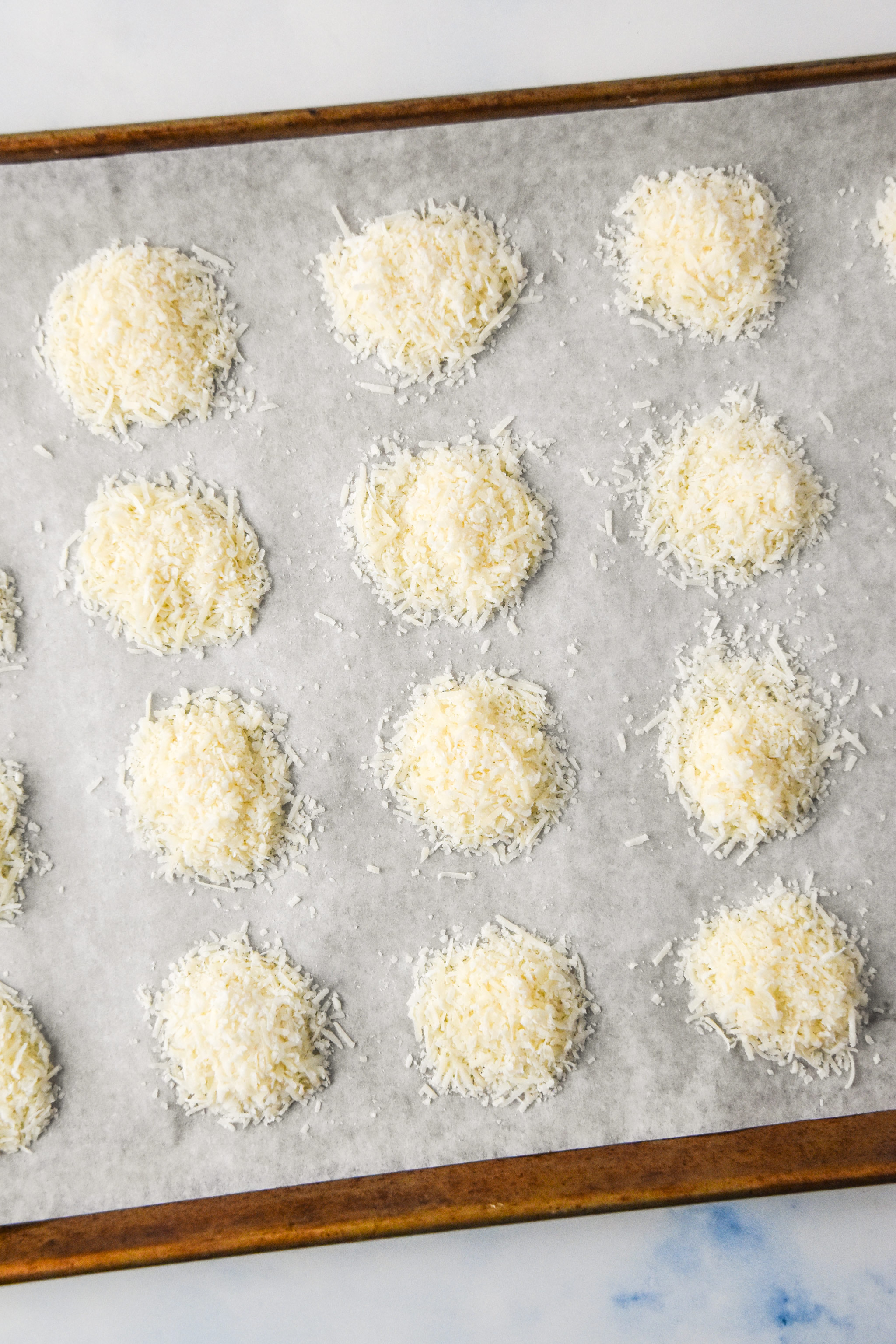 piles of parmesan cheese on a baking sheet top view