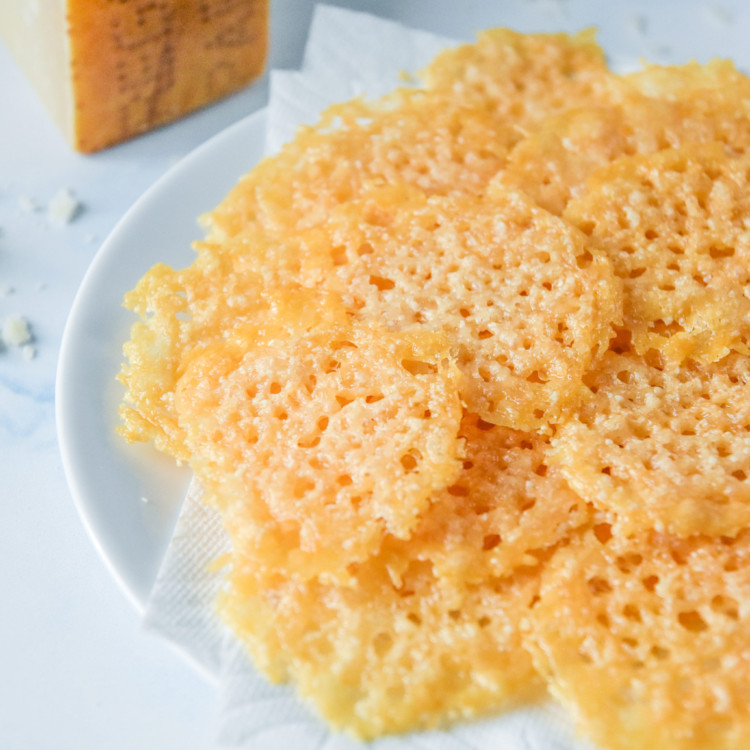 baked parmesan crisps on a plate lined with a paper towel