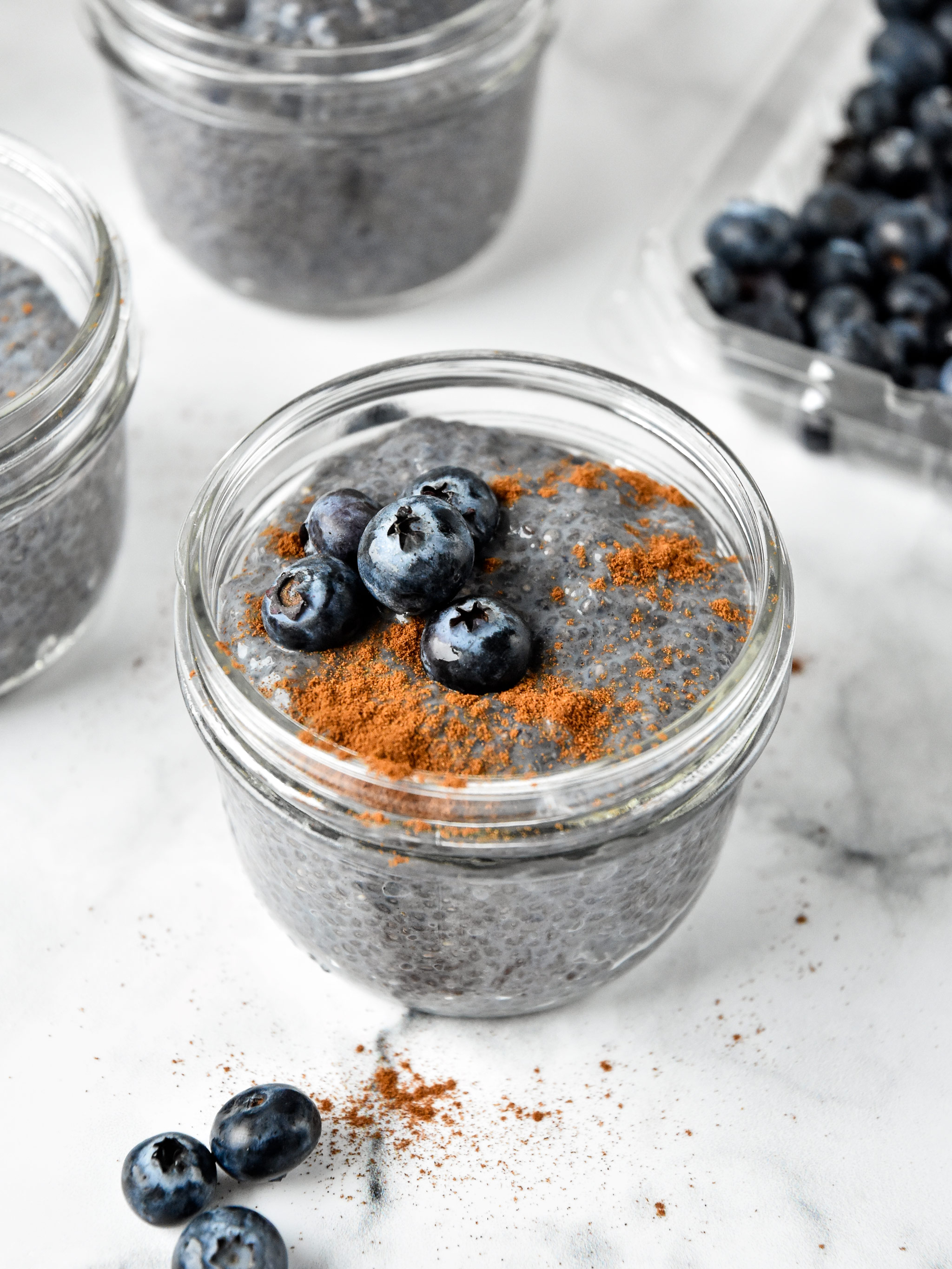 blueberry spice chia pudding in a mason jar with blueberries on top