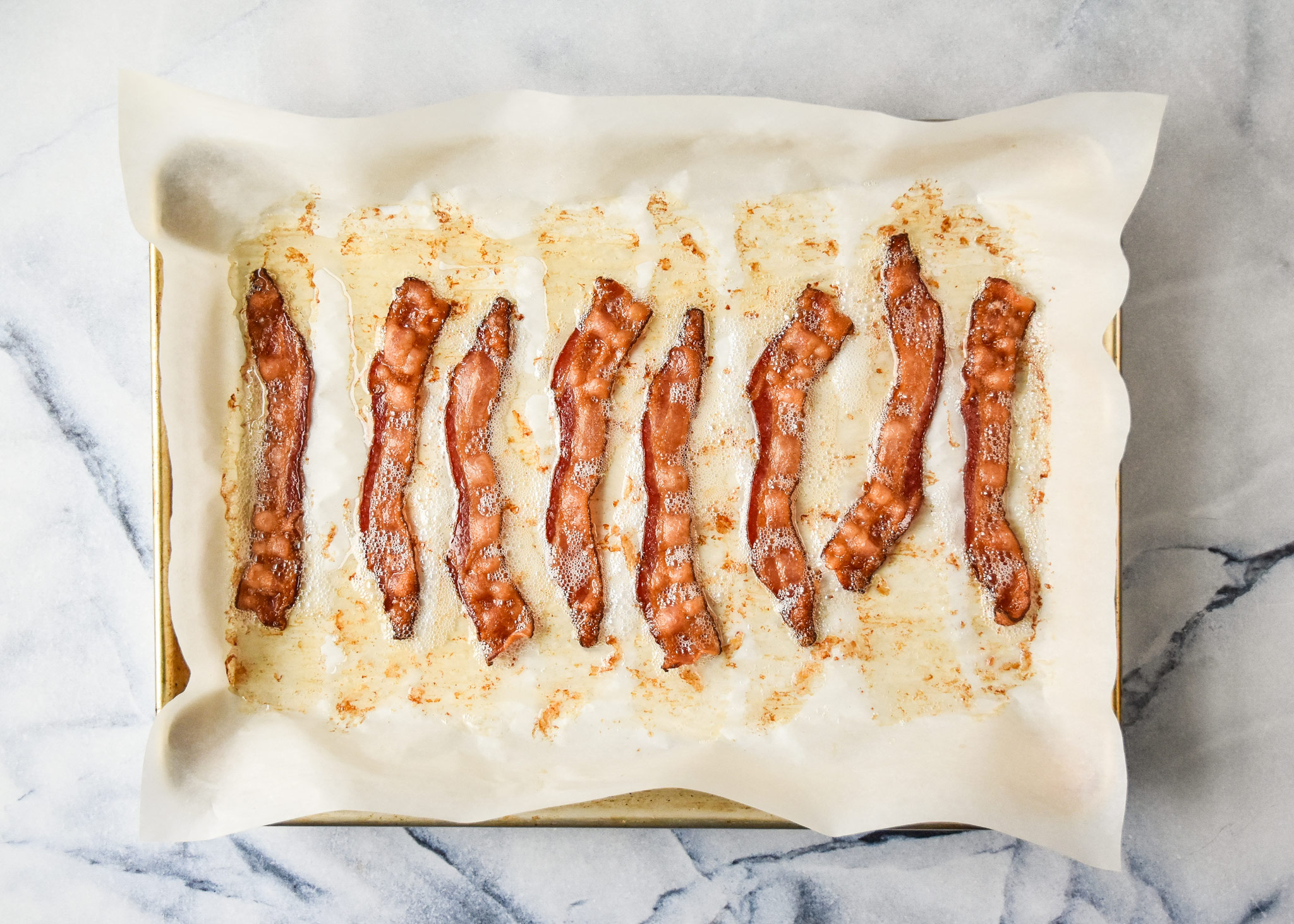 cooked bacon on parchment paper made in the oven