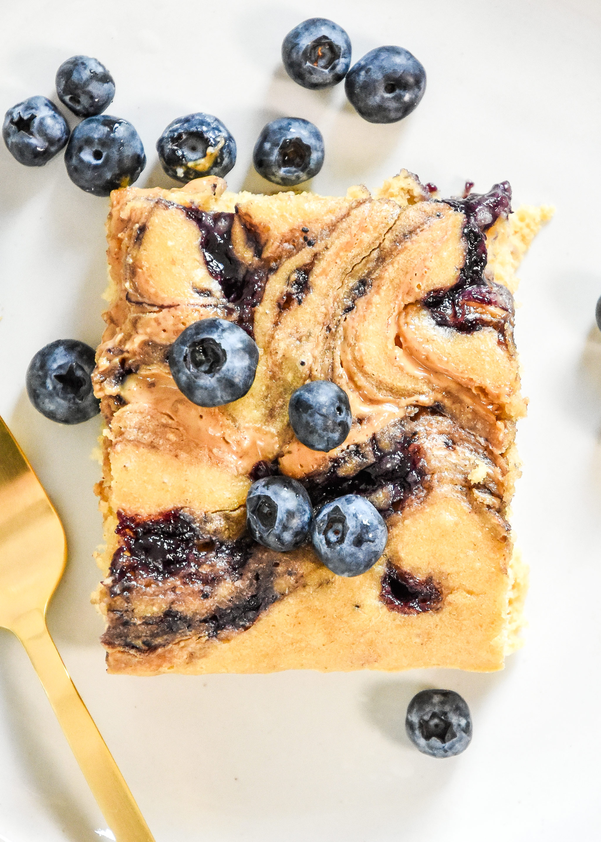 a perfect slice of peanut butter and jelly baked pancakes with blueberries on top