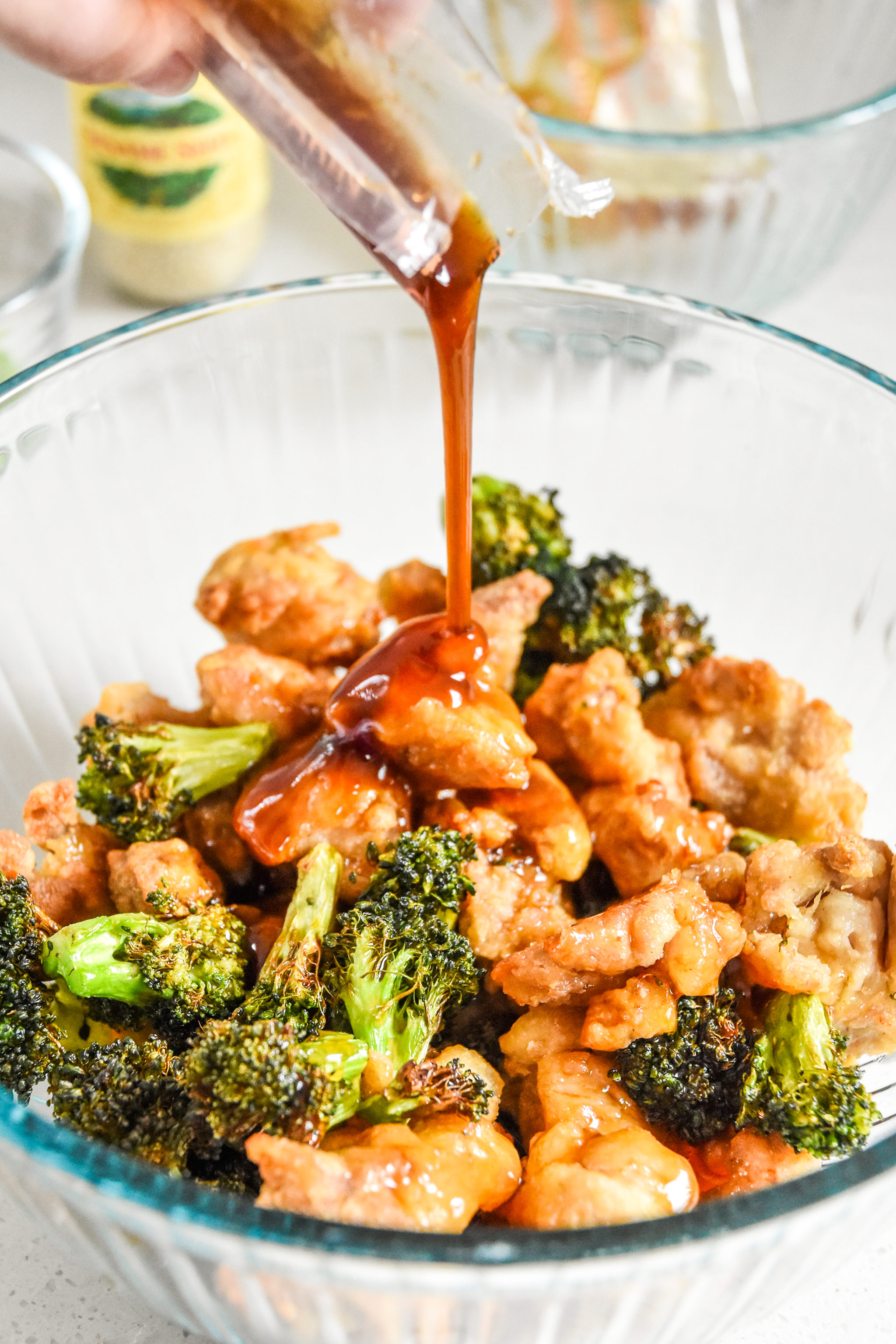 adding sauce to the air fryer trader joes orange chicken and broccoli meal