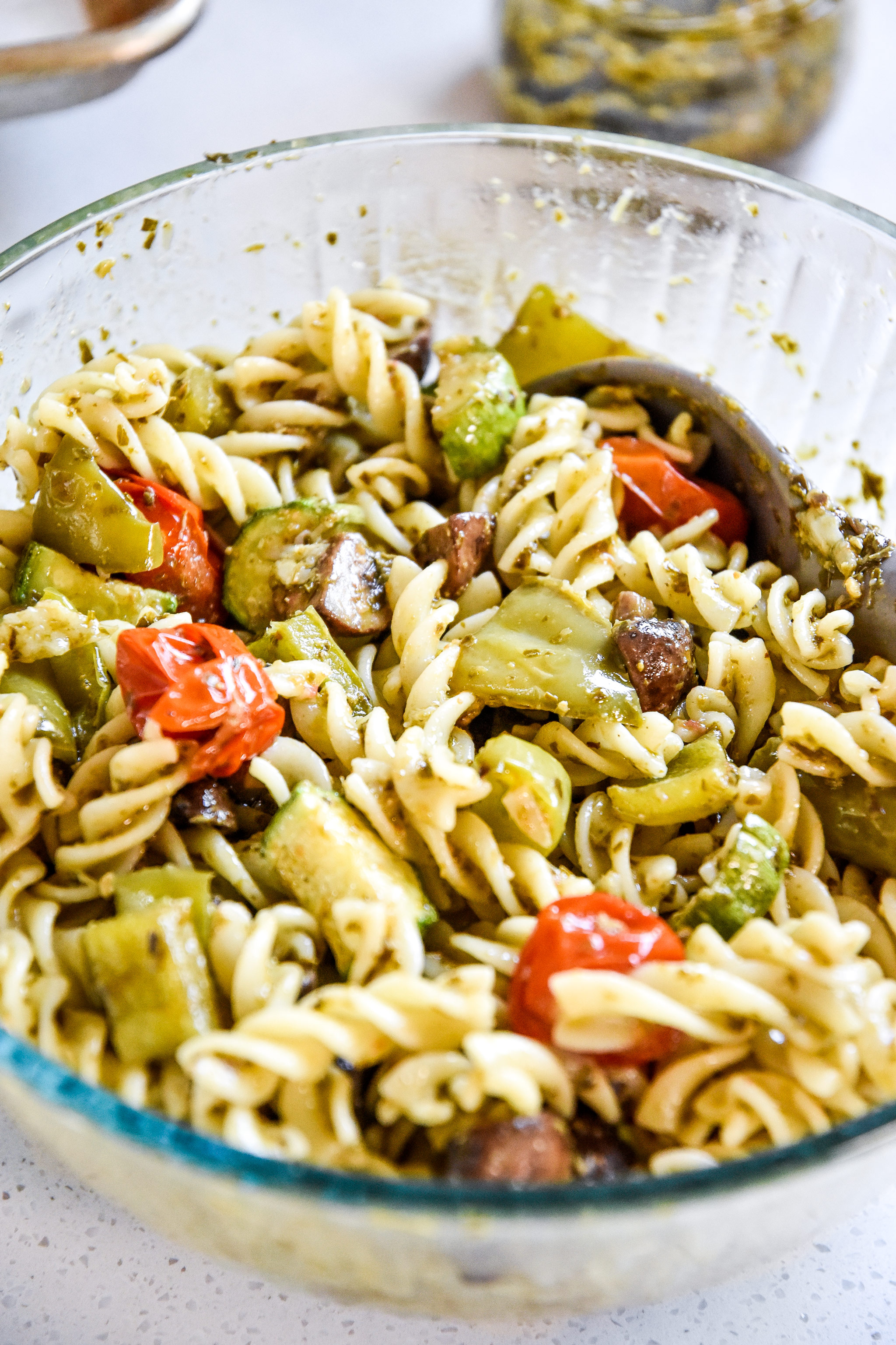 roasted veggie pesto pasta salad in a glass bowl