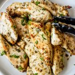 a plate of air fryer chicken tenders with tongs on the side.