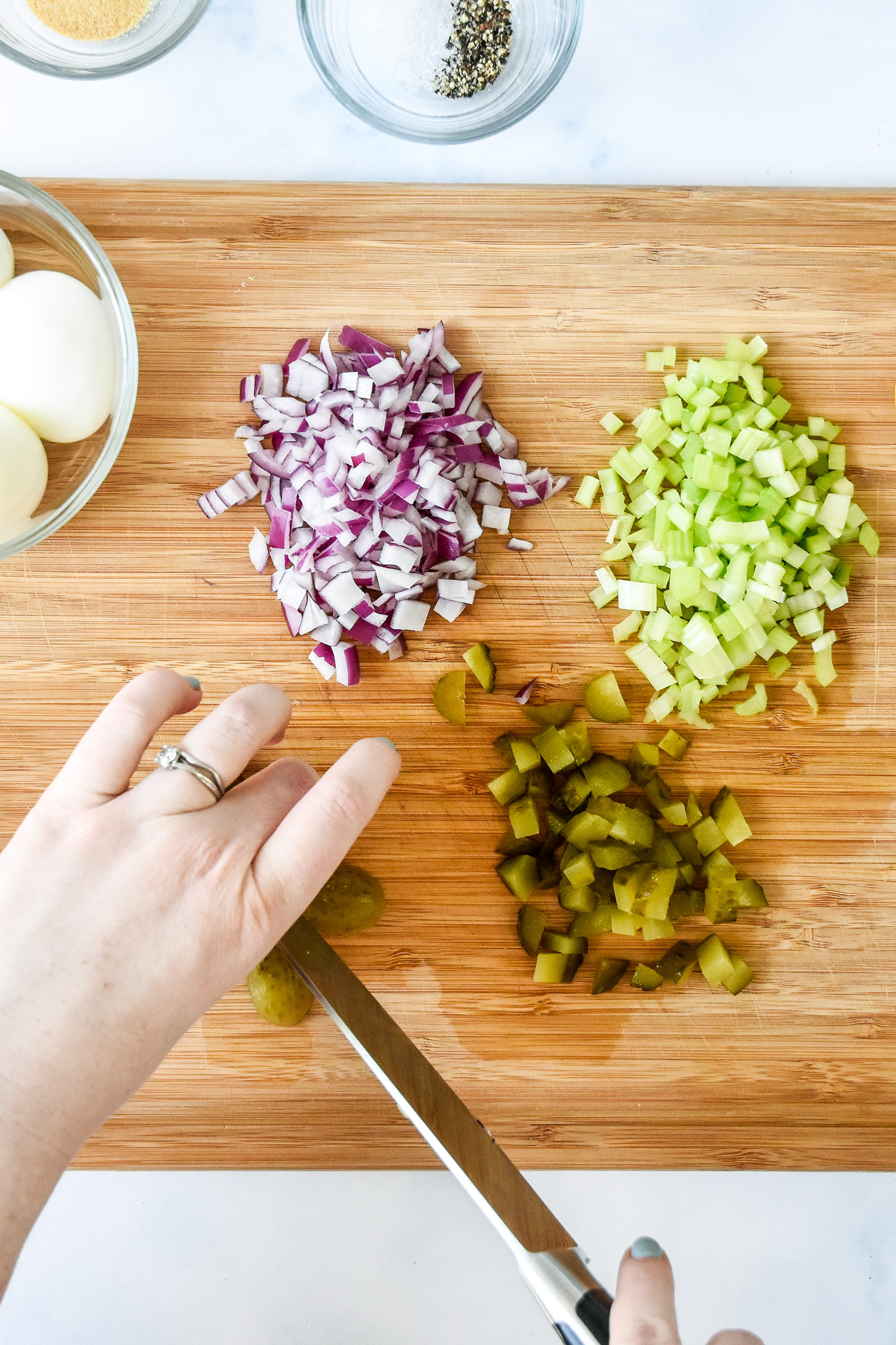 dicing and chopping the pickle and onion for tuna egg salad.