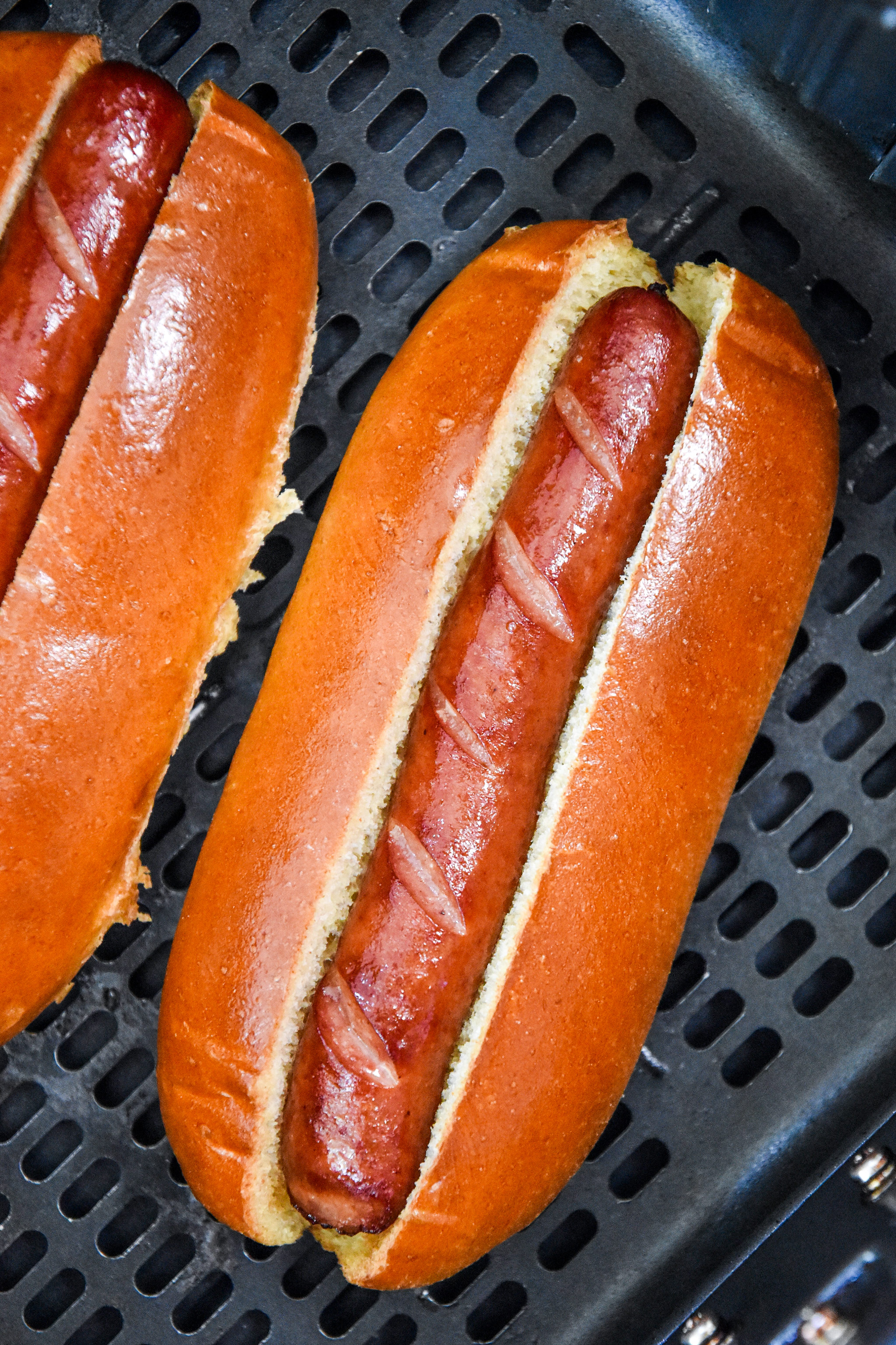 toasted buns and cooked hot dogs in the air fryer basket.