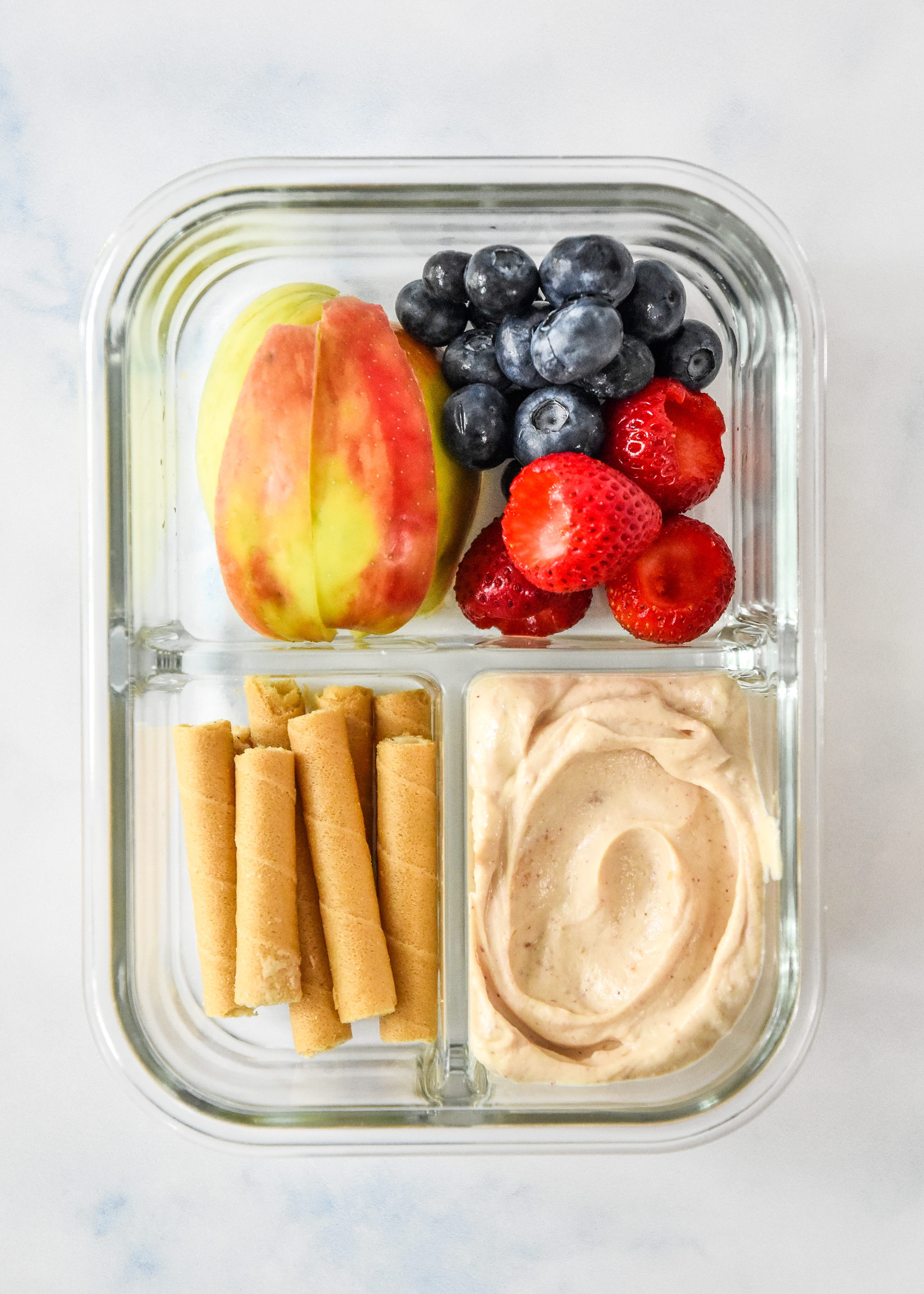 peanut butter fruit dip yogurt snack box with apple slices, berries and dip.