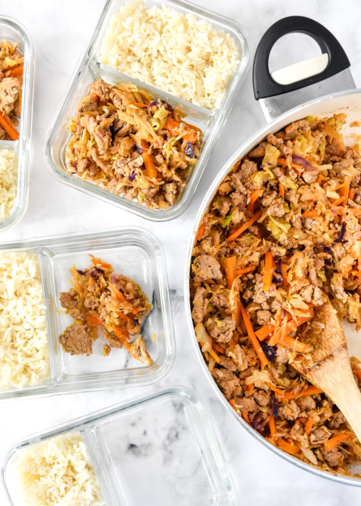 dishing up the ground turkey stir fry into meal prep bowls.