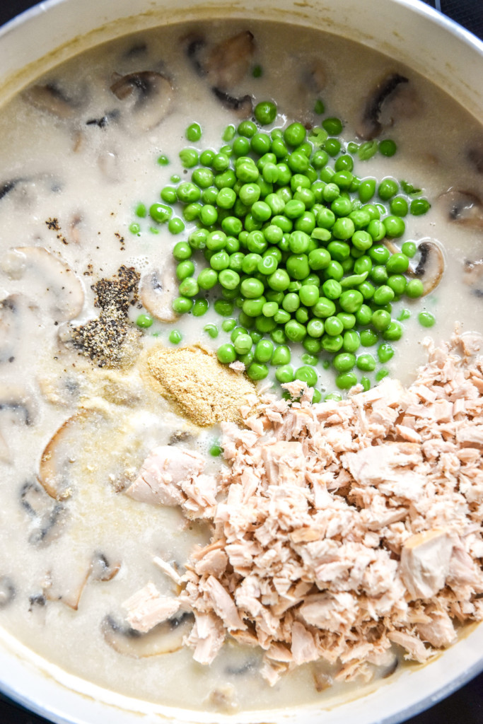 making sauce in a pan with tuna and peas on top.