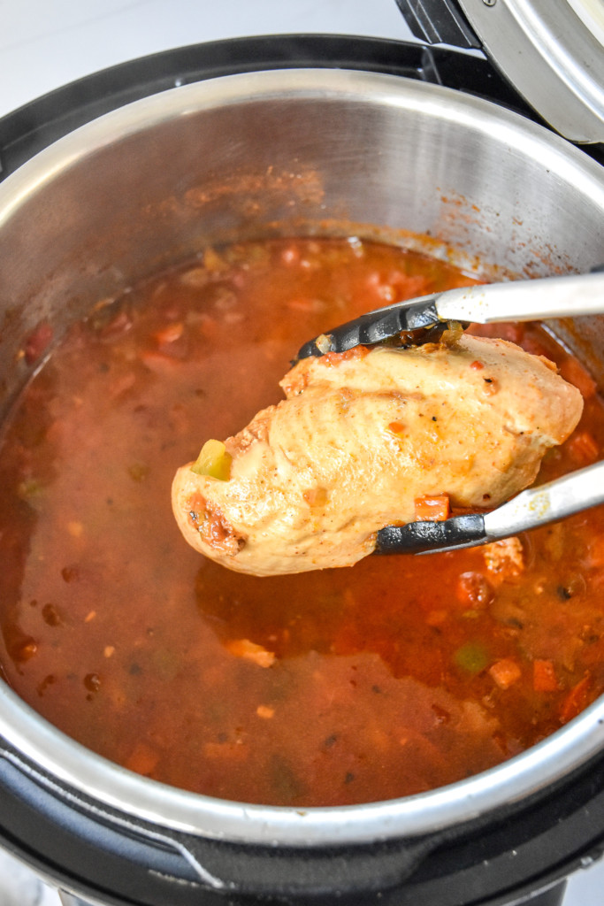 removing the cooked chicken breast from the instant pot.