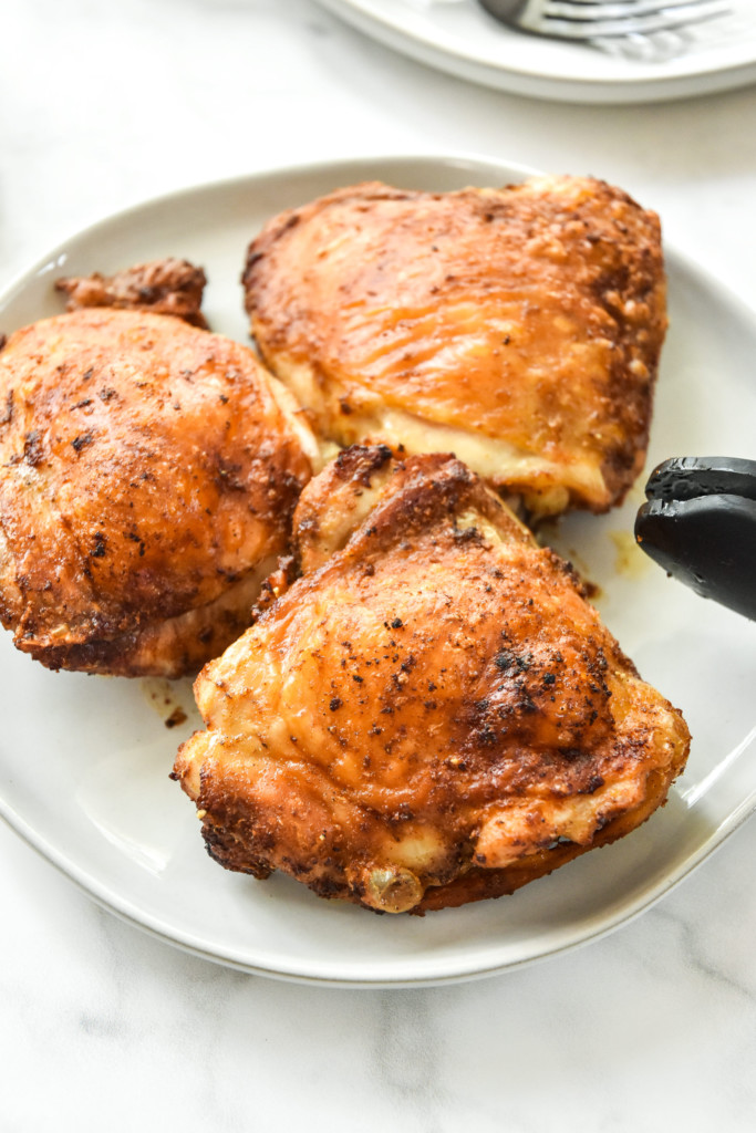 crispy chicken just cooked in the air fryer on a plate with tongs.
