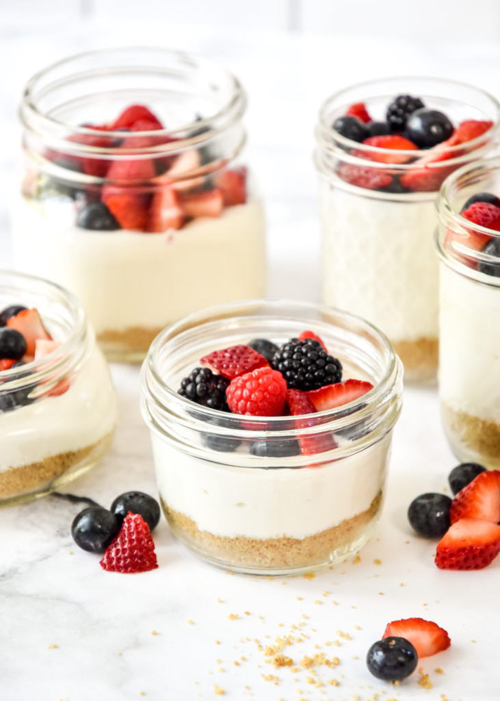 five jars of no-bake cheesecake greek yogurt cups in mason jars.