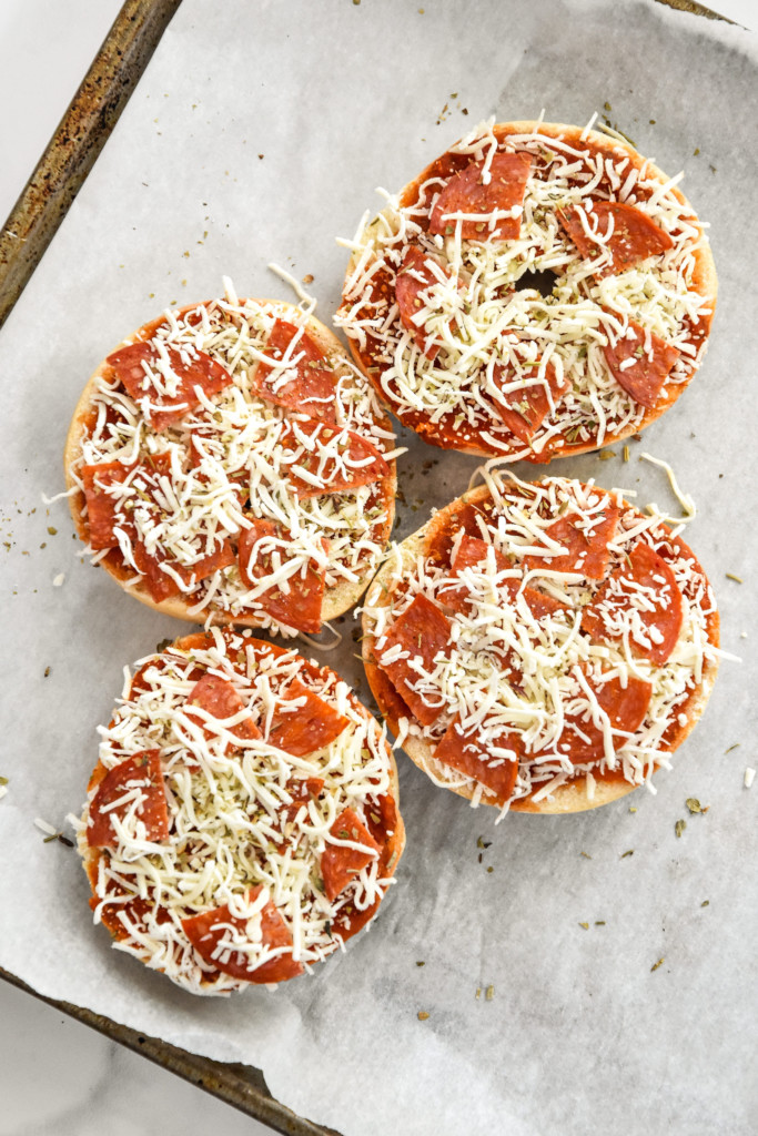 frozen assembled air fryer homemade pizza bagel bites on a sheet pan.