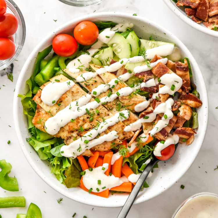 my go-to chicken bacon ranch salad in a white bowl with a fork.