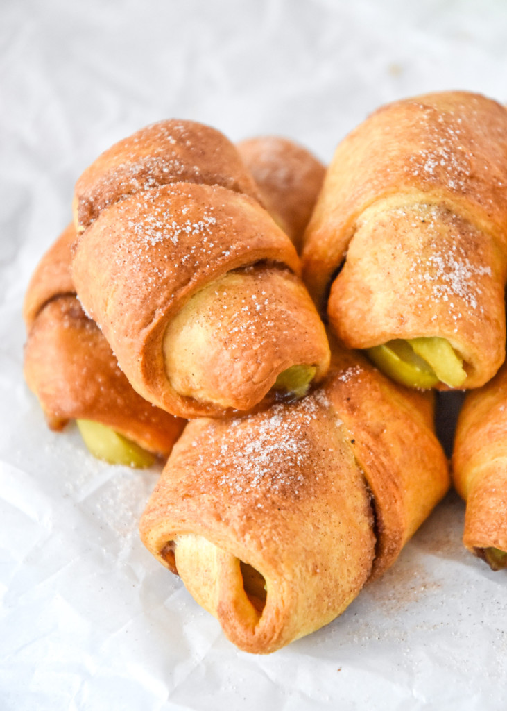 air fryer apple pie crescent rolls stacked with cinnamon sugar on top.