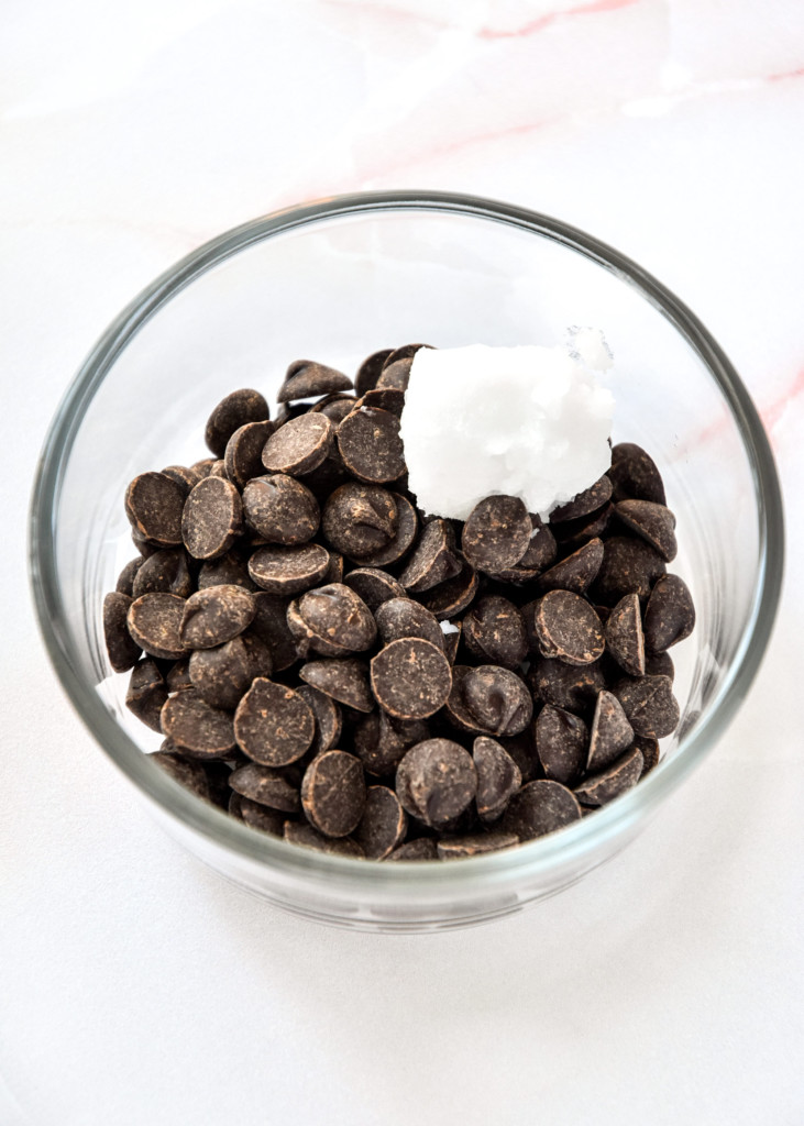 dark chocolate chips and coconut oil in a glass bowl for making the chocolate covered PB&J banana bites.