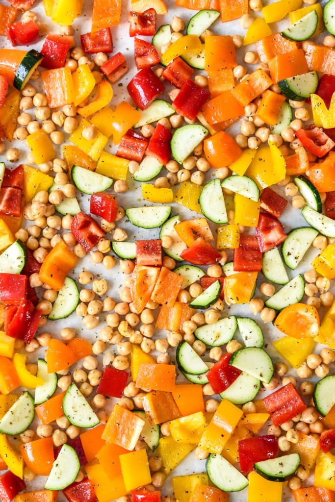 cut and seasoned vegetables close up on a sheet pan.