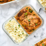 creamy tuscan chicken meal prep with rice in a glass meal prep container.