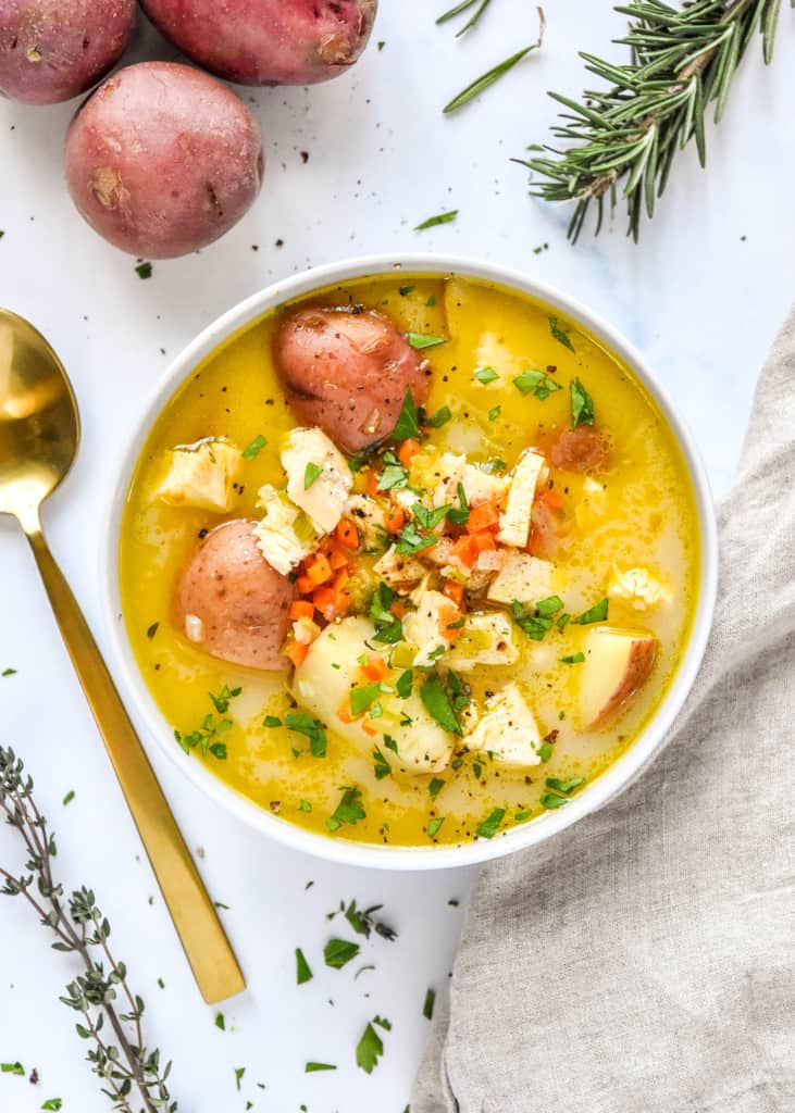simple red potato chicken soup in a bowl on a white table.
