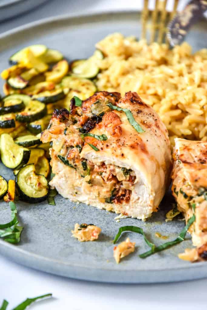 air fryer stuffed chicken breast cut in half on a plate served for dinner.