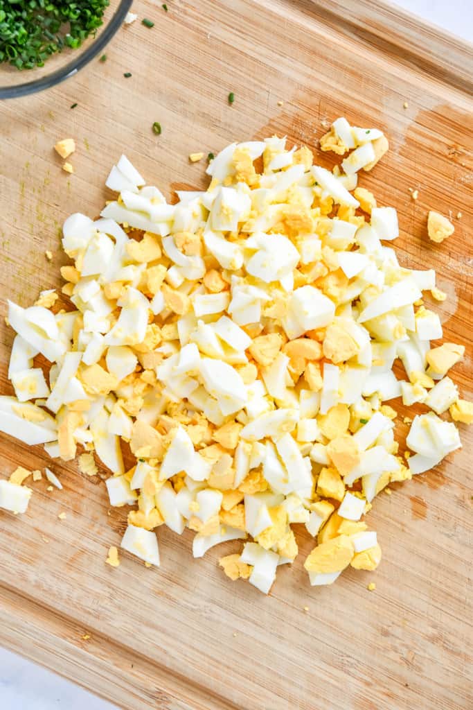 chopped hard boiled eggs on a cutting board for egg salad.
