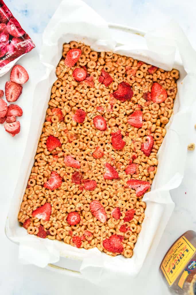 strawberry peanut butter cheerios bars in a white casserole dish.