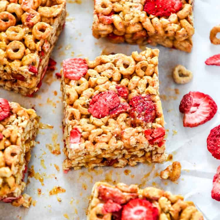 Strawberry Peanut Butter Cheerios Bars cut into squares on parchment paper.