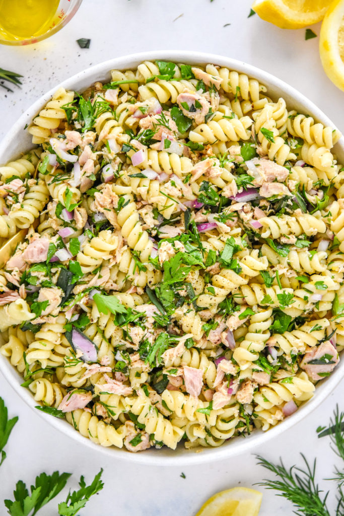 lemon vinaigrette tuna pasta salad with fresh herbs and lemons.