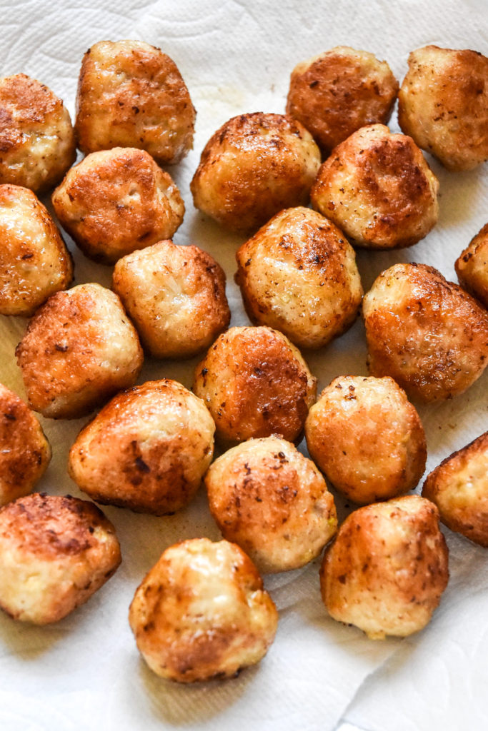 cooked chicken meatballs on a paper towel lined plate.
