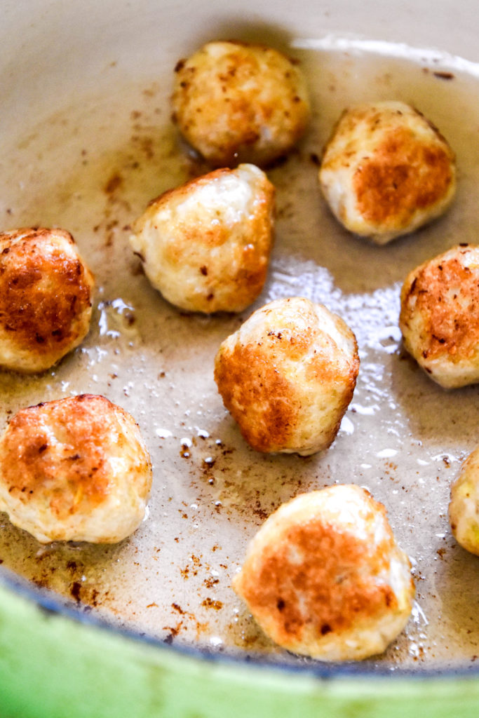 browning chicken meatballs in a dutch oven.