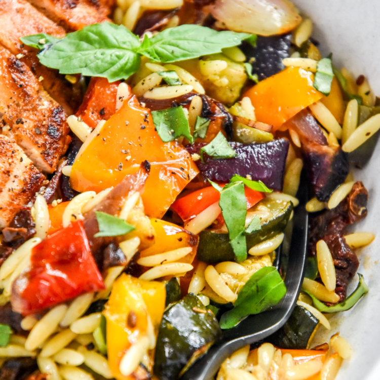 roasted vegetable orzo salad in a bowl with fork.