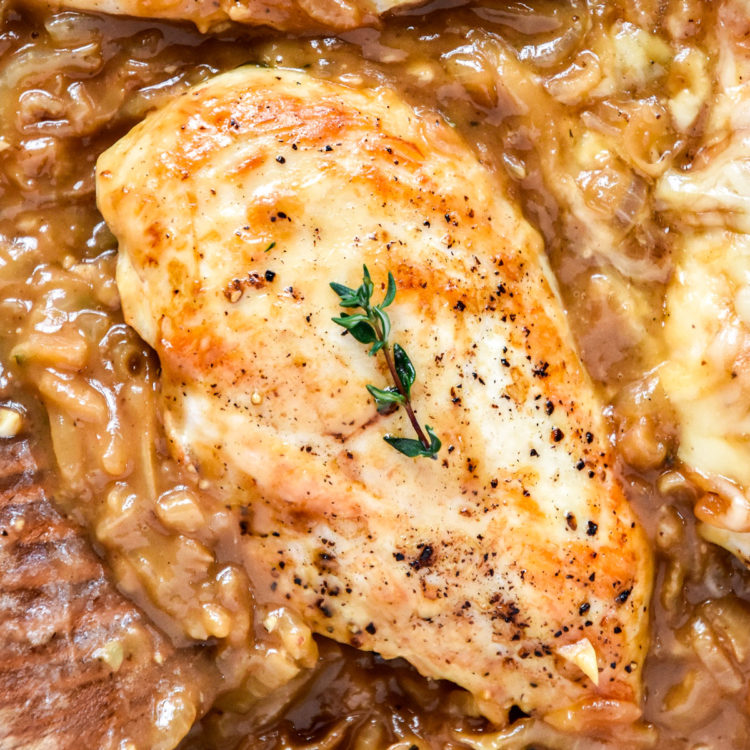 french onion baked chicken breasts in a pan with caramelized onions.