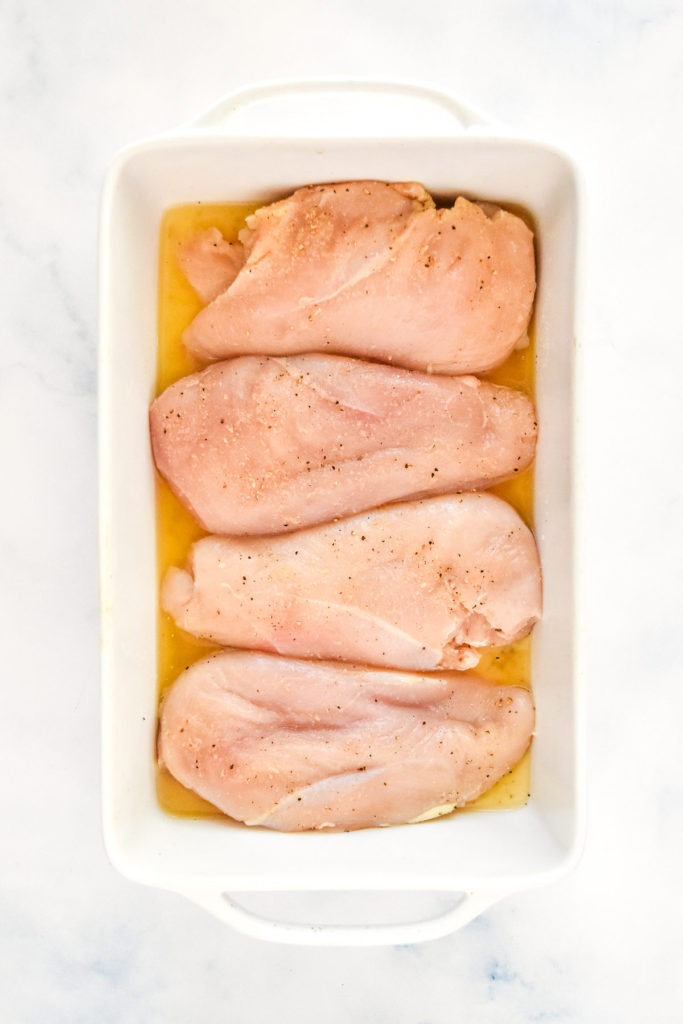 raw chicken breasts in a pan before cooking.