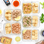 DIY flavored tuna packets with crackers in glass meal prep containers.