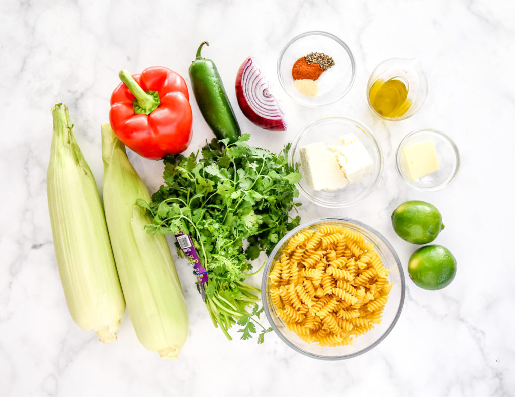 ingredients and fresh veggies required to make corn pasta salad.