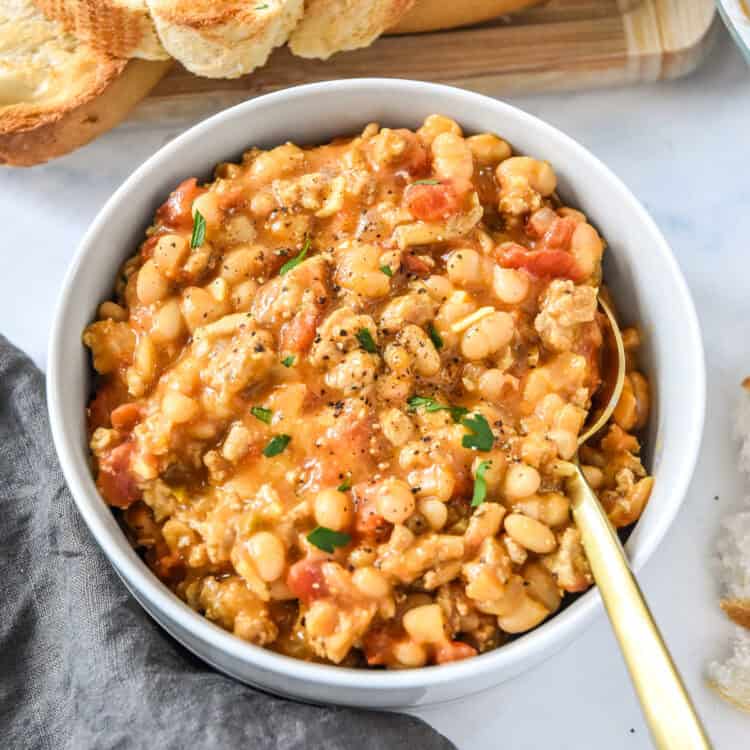 sloppy ground turkey white bean skillet dished up in a bowl with spoon.